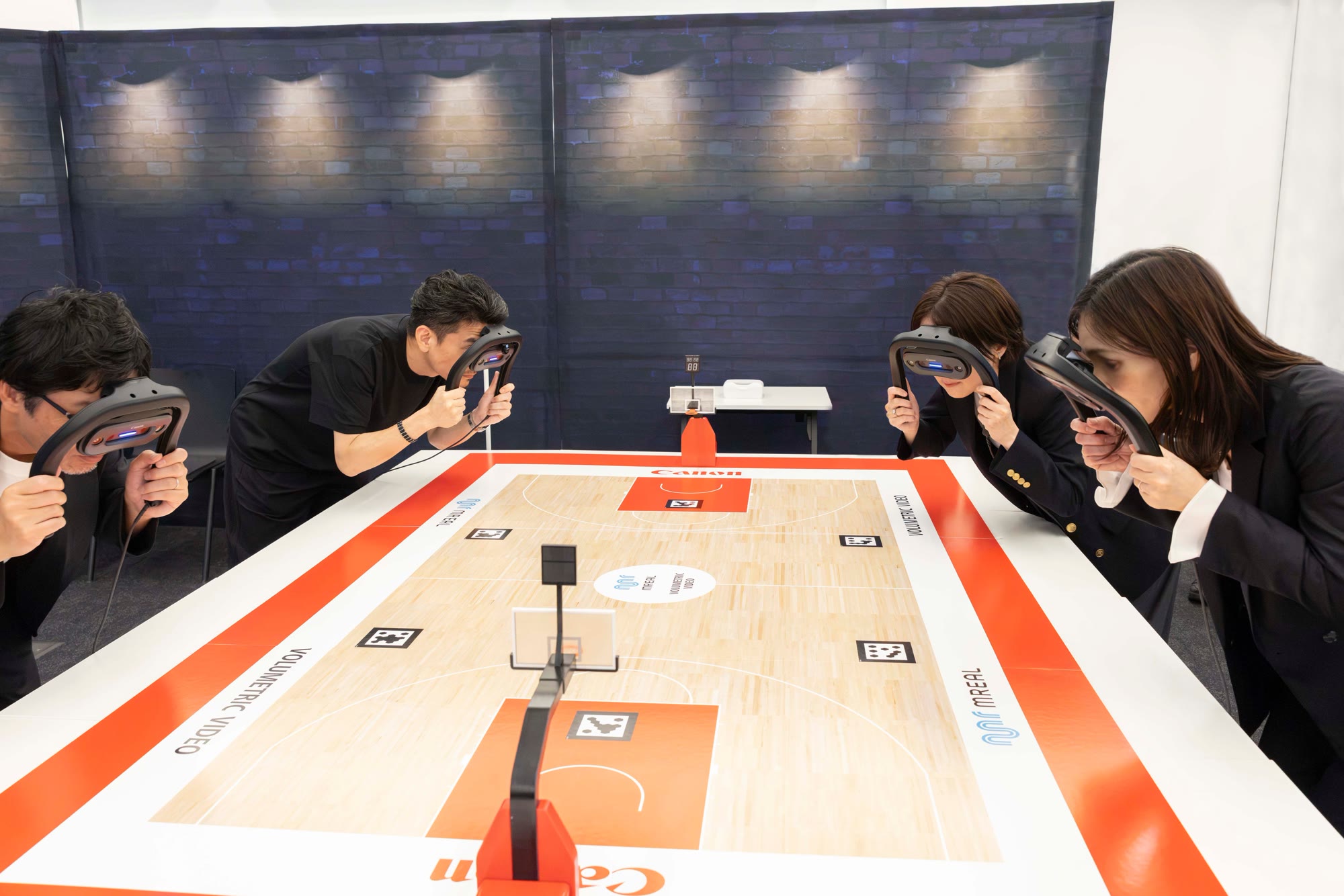Participants watching a remote Asian Games basketball volumetric MR demo on a tabletop display