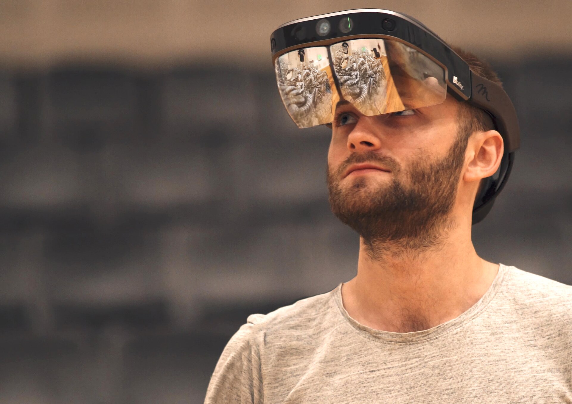 Person wearing an AR headset with a transparent visor close to the face and ears — the contact zone that makes temple heat a burn hazard