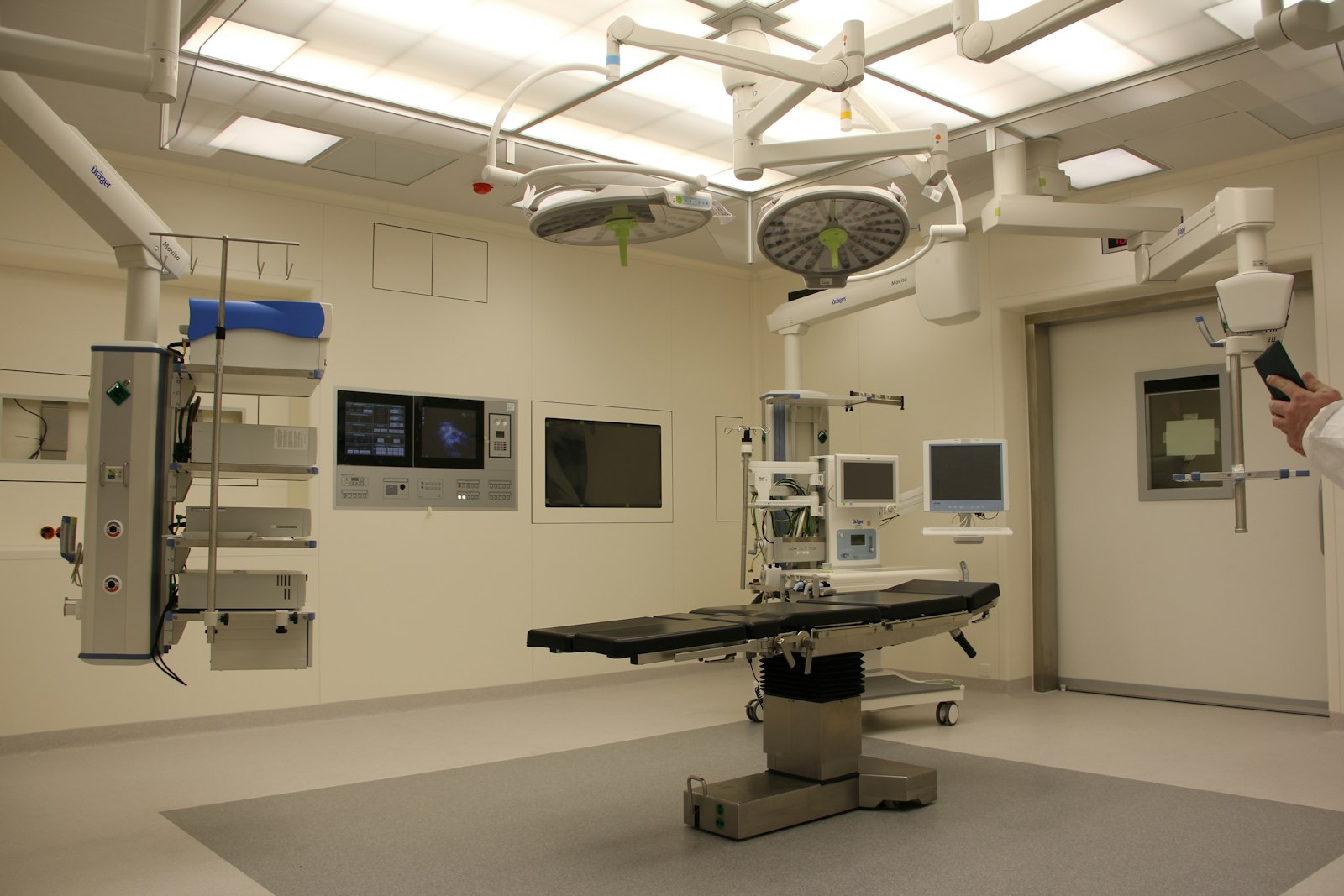 Modern hospital operating room with digital displays and boom arms — healthcare is the second Personal AI Health Alliance target