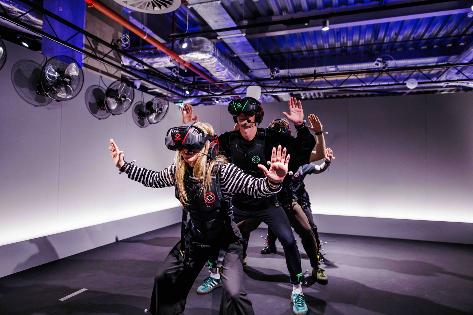 Guests in Sandbox VR free-roam kits with headsets and haptic vests