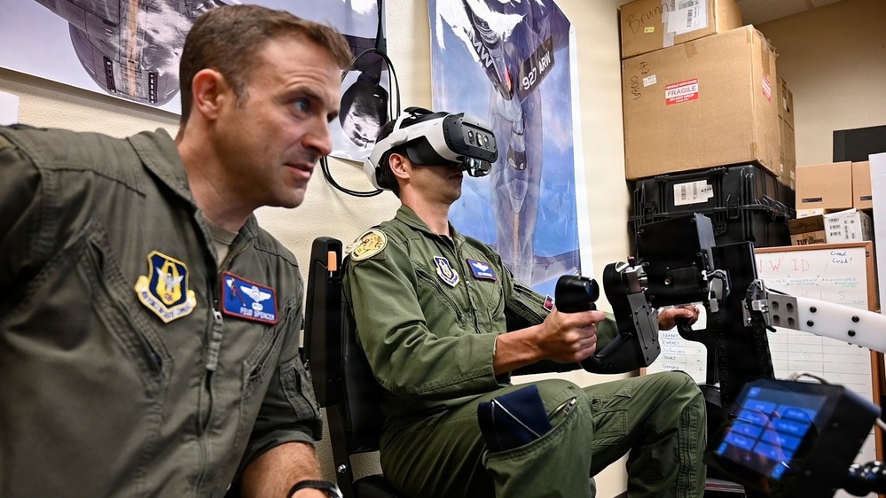 An Air Force officer observes as a teammate practices B-52H air refueling on the EARL VR trainer at Barksdale Air Force Base