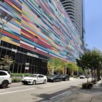 Ray-Ban Meta Wayfarer smart glasses on a colorful Brickell facade