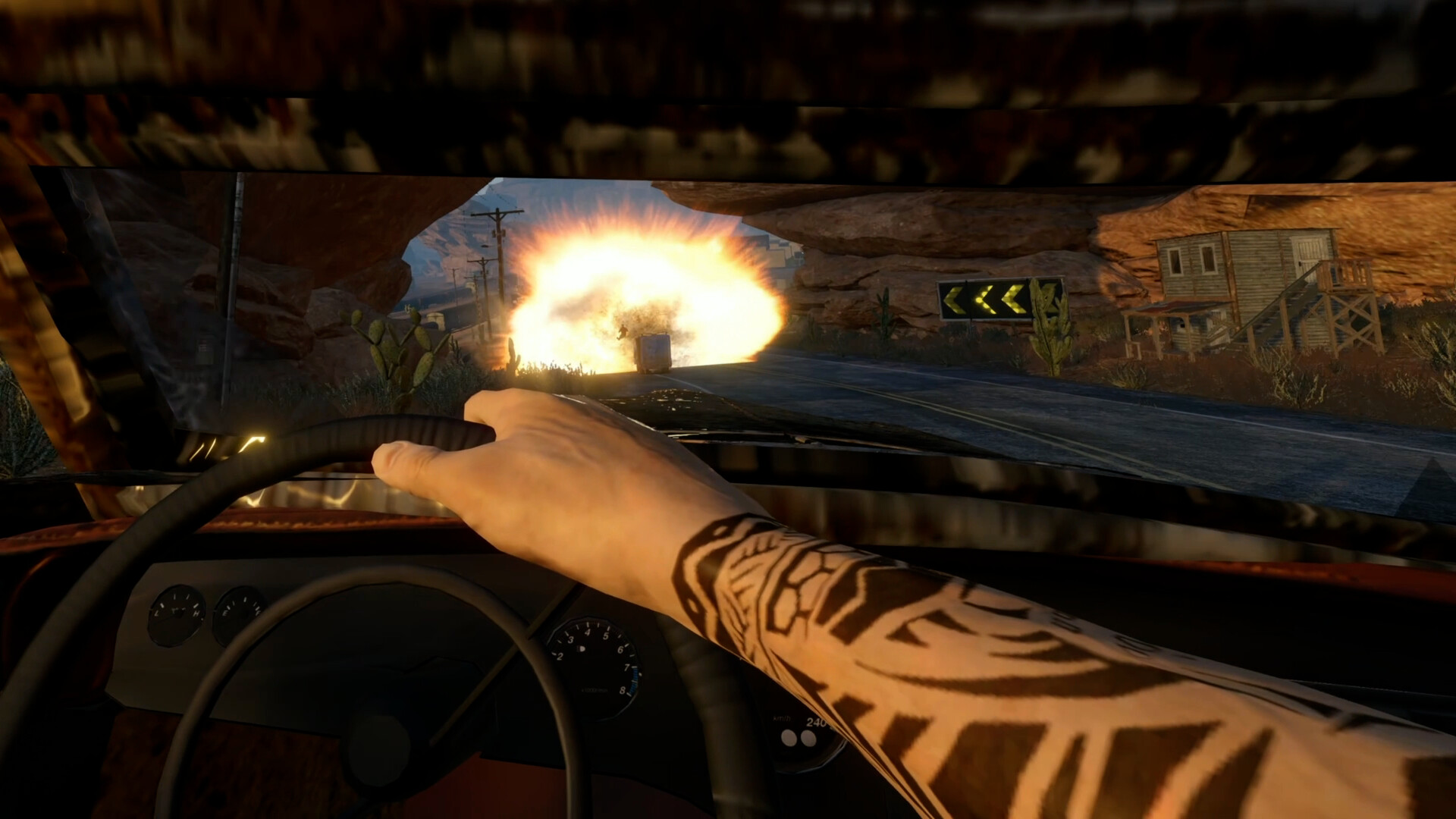 FlatOut 4: Total Insanity VR driver's view of an explosion ahead on a desert road, seen through a cracked windshield