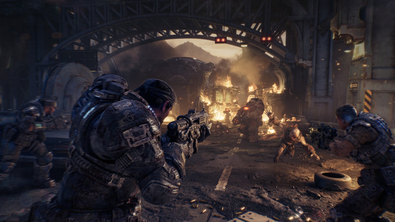 Marcus Fenix and squadmates fire on Locust troops beneath a burning bridge in a Gears of War: E-Day campaign screenshot