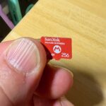 A SanDisk microSD Express 256GB card held between thumb and finger (Wikimedia Commons, Kyu3a, CC BY-SA 4.0)